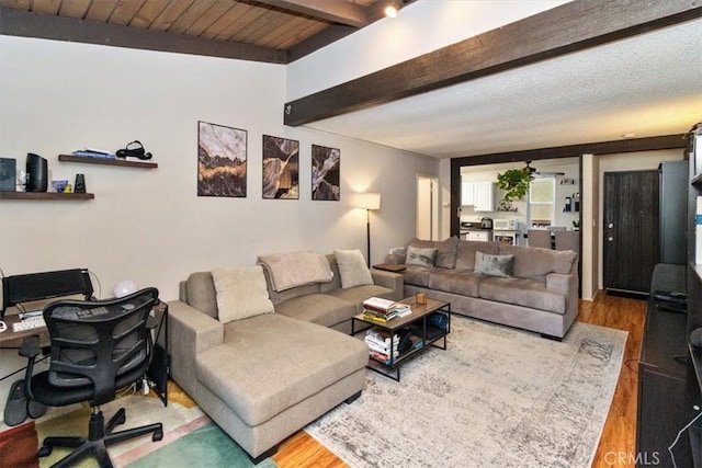 living room featuring a textured ceiling, hardwood / wood-style flooring, beamed ceiling, and wooden ceiling