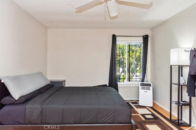 bedroom with a textured ceiling and dark hardwood / wood-style floors