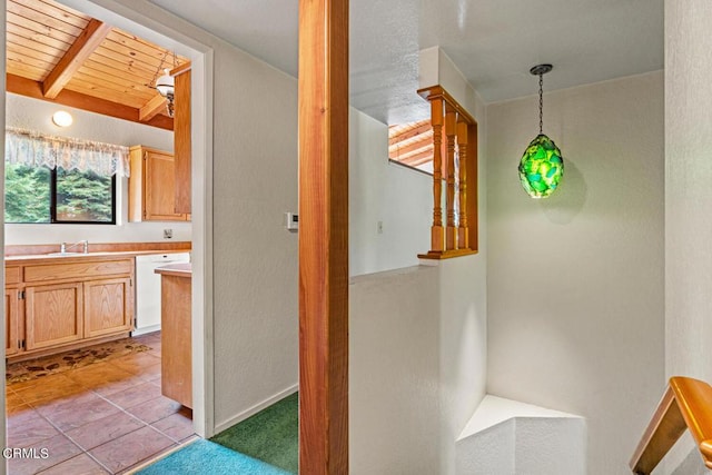 interior space with vaulted ceiling with beams, wooden ceiling, sink, and light tile patterned floors