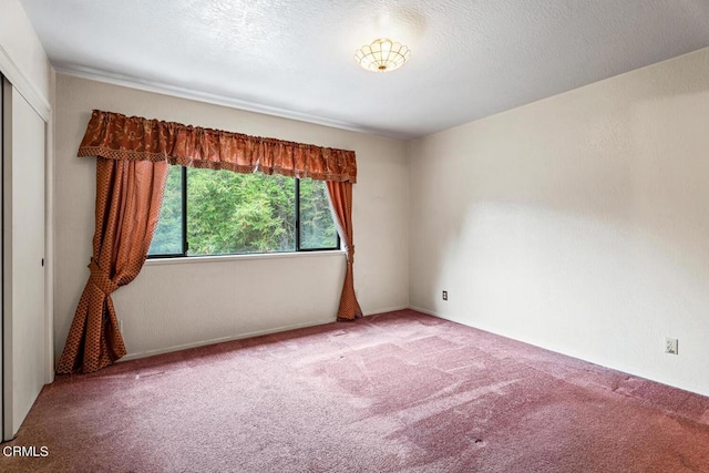 carpeted empty room with a textured ceiling