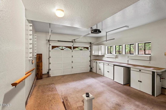 garage featuring stainless steel fridge and a garage door opener