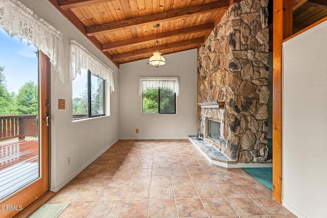 unfurnished living room with wood ceiling, a stone fireplace, light tile patterned floors, and lofted ceiling with beams