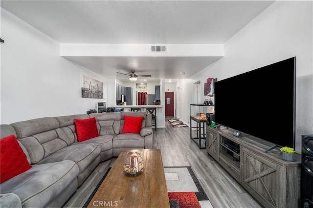 living room with ceiling fan and light wood-type flooring