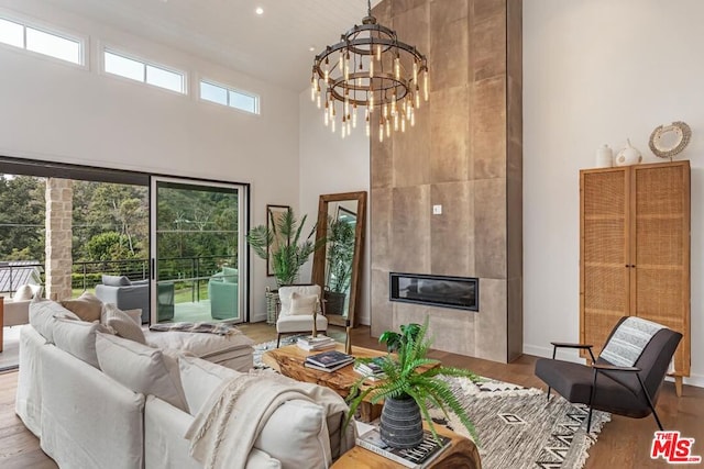 living room with a fireplace, wood-type flooring, and a high ceiling