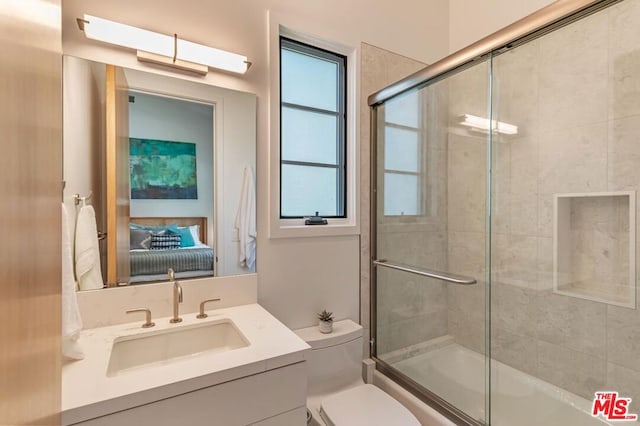 full bathroom featuring vanity, toilet, and bath / shower combo with glass door