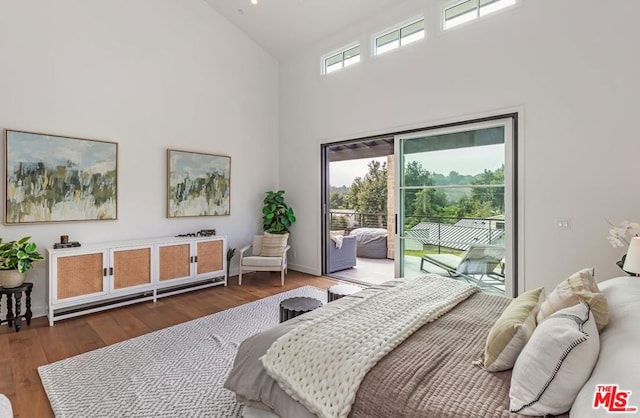 bedroom with access to exterior, high vaulted ceiling, and dark hardwood / wood-style flooring