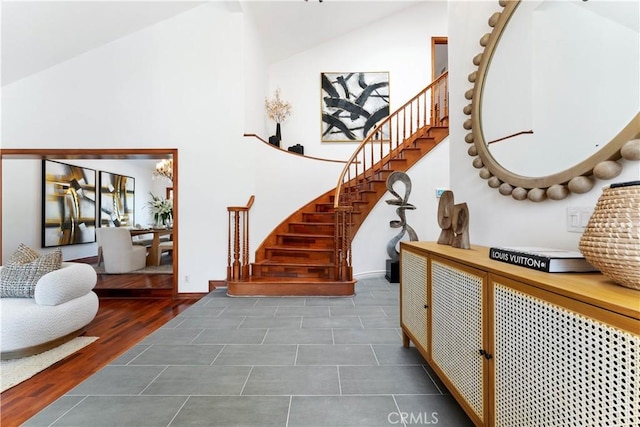 staircase featuring hardwood / wood-style floors and high vaulted ceiling