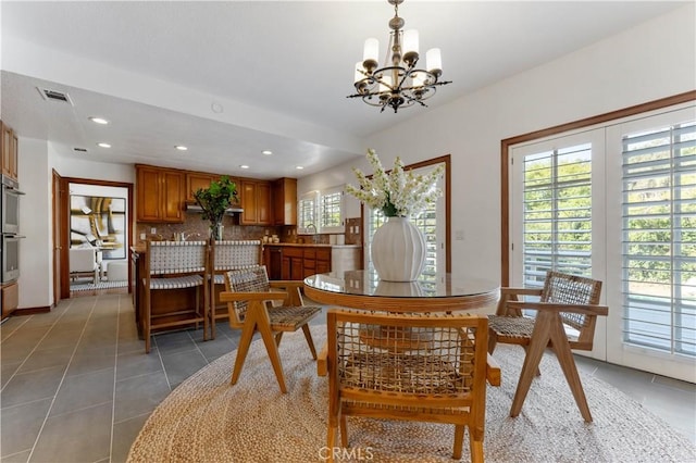 tiled dining space with plenty of natural light and an inviting chandelier