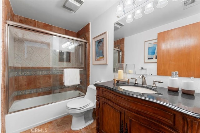 full bathroom with tile patterned flooring, enclosed tub / shower combo, vanity, and toilet