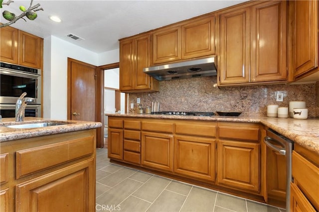 kitchen featuring sink, backsplash, light tile patterned floors, light stone counters, and stainless steel appliances