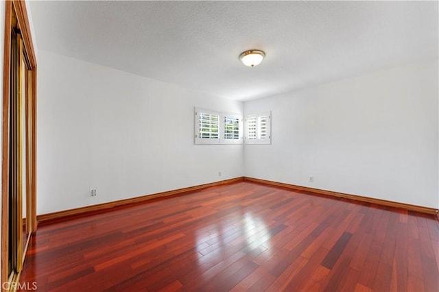 unfurnished room with wood-type flooring