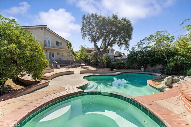 view of swimming pool with a patio area and an in ground hot tub