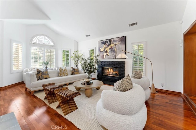 living room featuring dark hardwood / wood-style flooring, lofted ceiling, and a fireplace