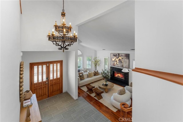 entryway with a notable chandelier, dark hardwood / wood-style floors, and lofted ceiling