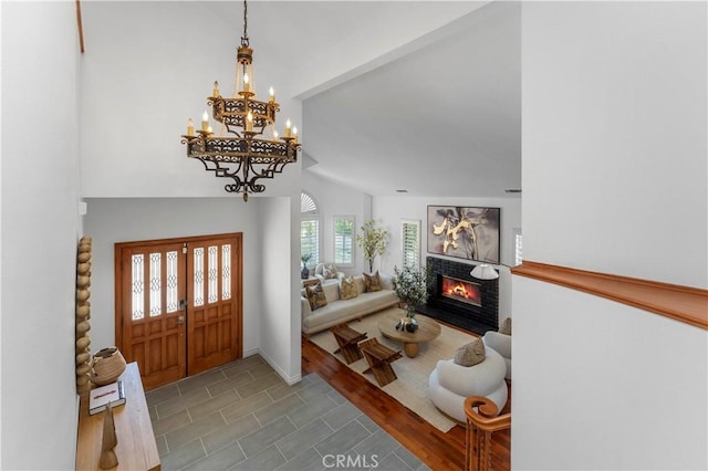 entrance foyer featuring a tile fireplace and vaulted ceiling