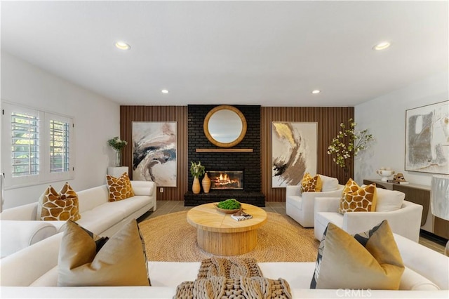 living room featuring a brick fireplace and light tile patterned floors