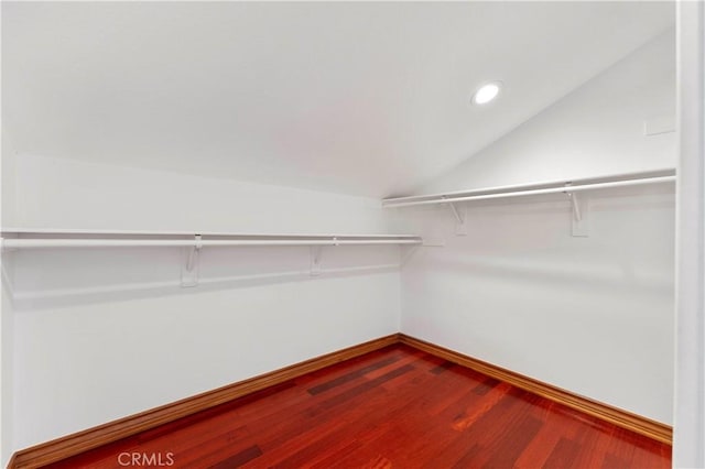 spacious closet with hardwood / wood-style flooring and lofted ceiling