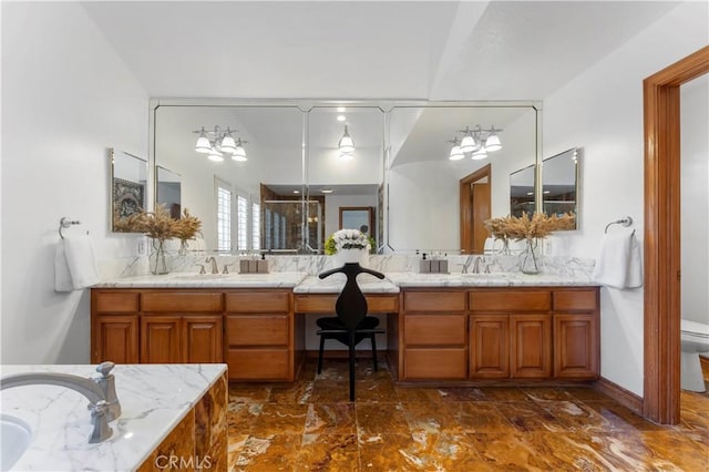 bathroom with vanity, toilet, and a chandelier