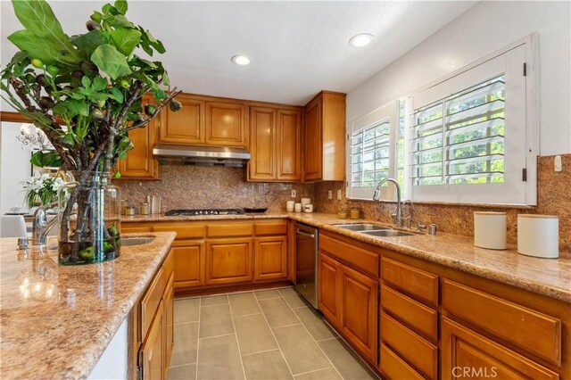 kitchen with sink, decorative backsplash, light stone countertops, light tile patterned flooring, and stainless steel appliances