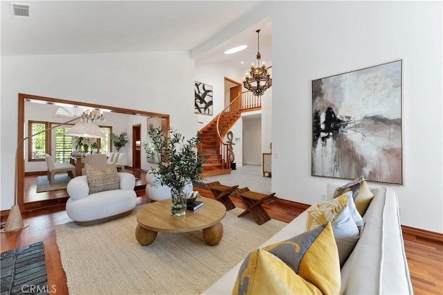 living room featuring hardwood / wood-style floors, high vaulted ceiling, and a notable chandelier