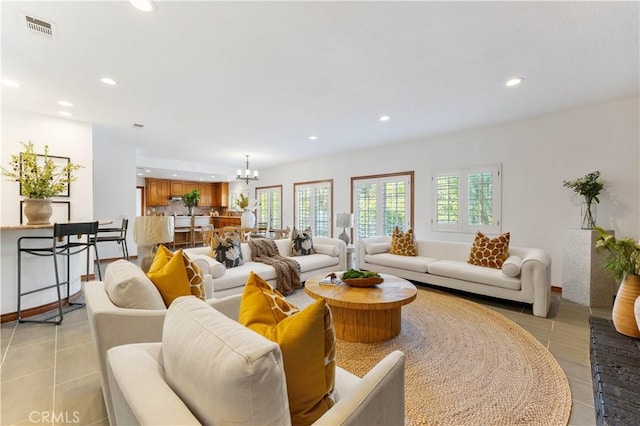 living room with a notable chandelier and light tile patterned flooring