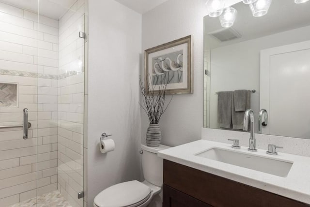 bathroom with toilet, a shower with shower door, and vanity