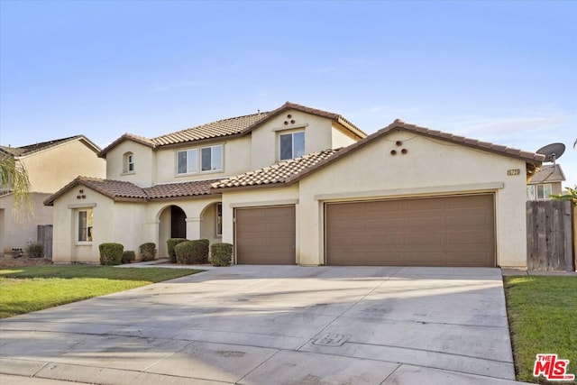 mediterranean / spanish home with a front yard and a garage