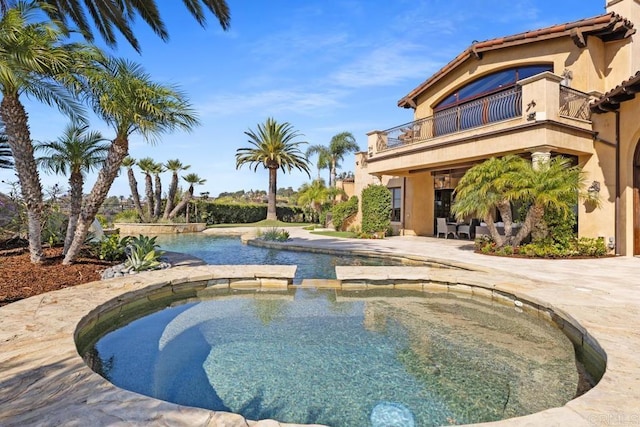 view of pool featuring an in ground hot tub