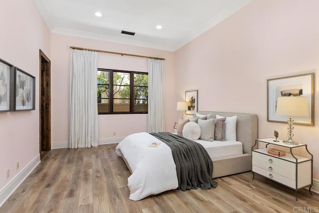 bedroom featuring ornamental molding and light hardwood / wood-style floors