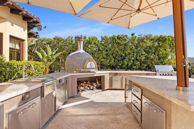 view of patio / terrace featuring an outdoor kitchen and a grill