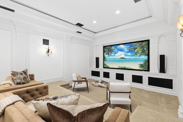 carpeted cinema room featuring ornamental molding and a tray ceiling