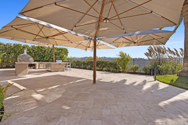 view of patio with exterior kitchen and a bar