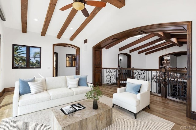 living room with lofted ceiling with beams, wood-type flooring, and ceiling fan with notable chandelier