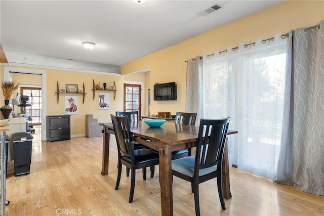 dining space with plenty of natural light and light wood-type flooring