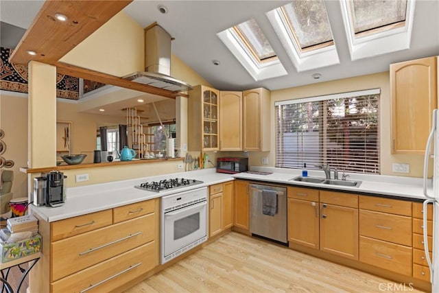 kitchen with white appliances, sink, light wood-type flooring, light brown cabinetry, and kitchen peninsula