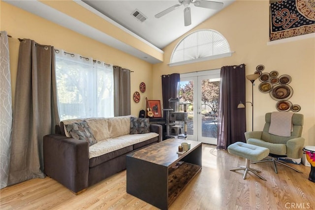 living room with french doors, light hardwood / wood-style floors, high vaulted ceiling, and ceiling fan