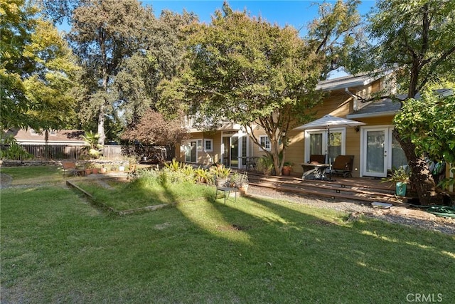 rear view of house with a lawn and a wooden deck