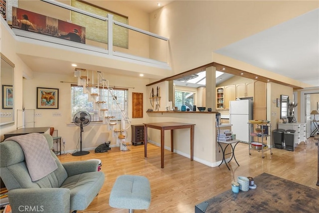 living room featuring light wood-type flooring and a high ceiling