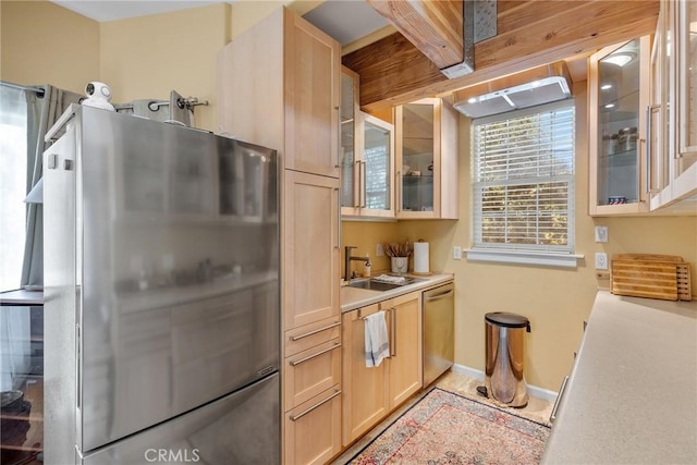 kitchen with light brown cabinetry, stainless steel appliances, and sink