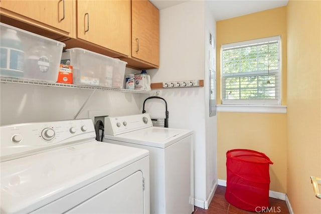 washroom featuring washer and clothes dryer, dark tile patterned floors, and cabinets