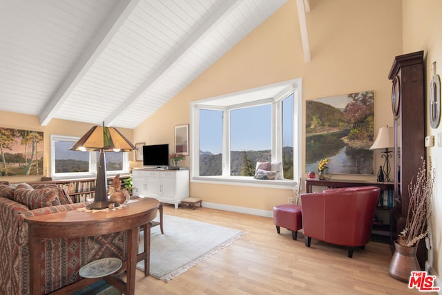 living room with high vaulted ceiling, beamed ceiling, and light hardwood / wood-style flooring