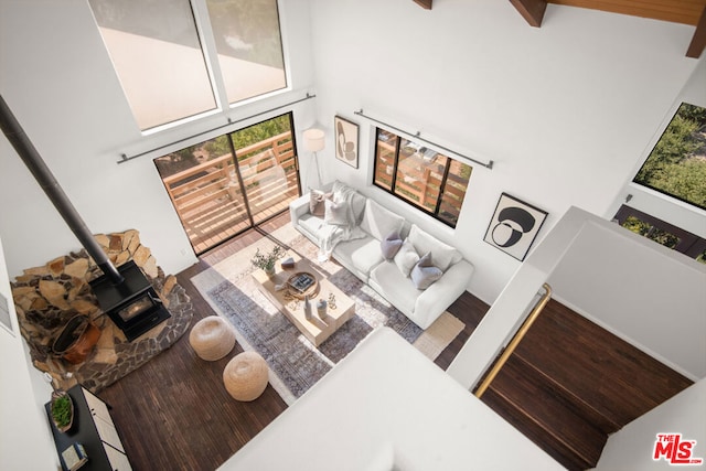 living room featuring a wood stove and a high ceiling