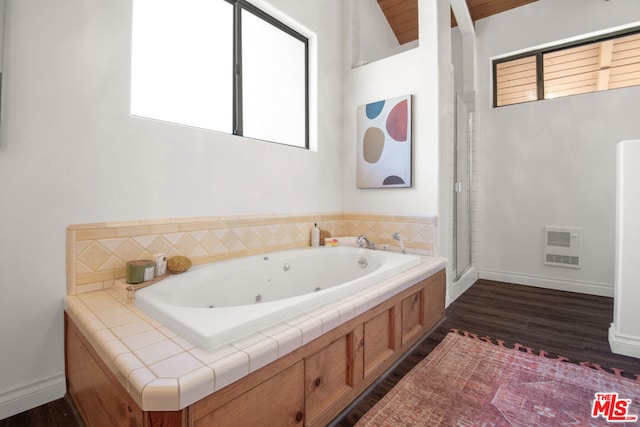 bathroom with a tub to relax in and wood-type flooring