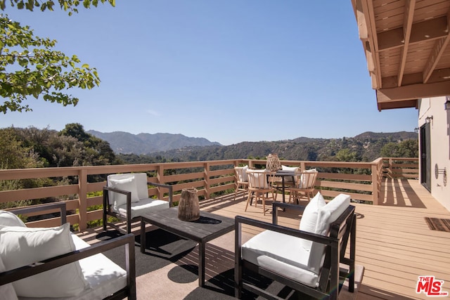 wooden terrace featuring a mountain view and outdoor lounge area