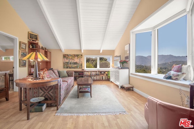 living room with lofted ceiling with beams and light wood-type flooring