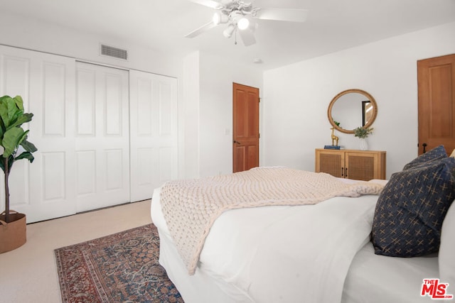 carpeted bedroom featuring ceiling fan and a closet