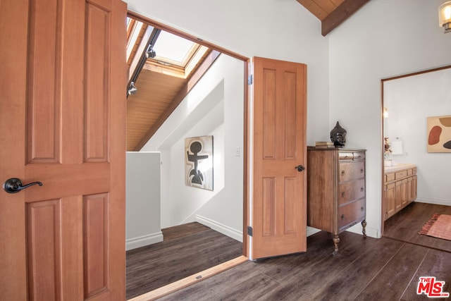 hall with dark wood-type flooring, vaulted ceiling with skylight, and wood ceiling