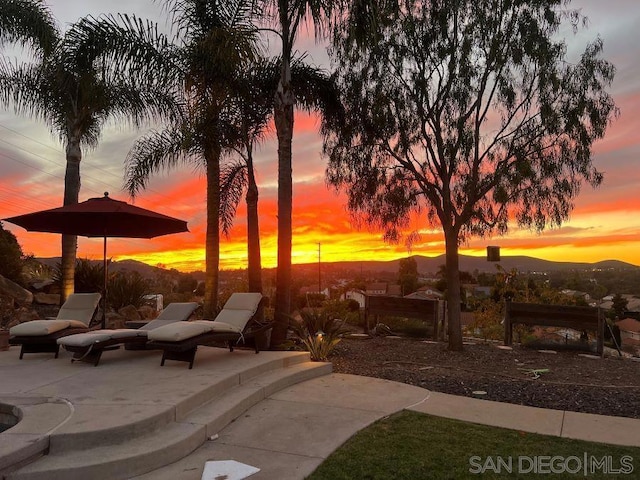 patio terrace at dusk featuring a mountain view