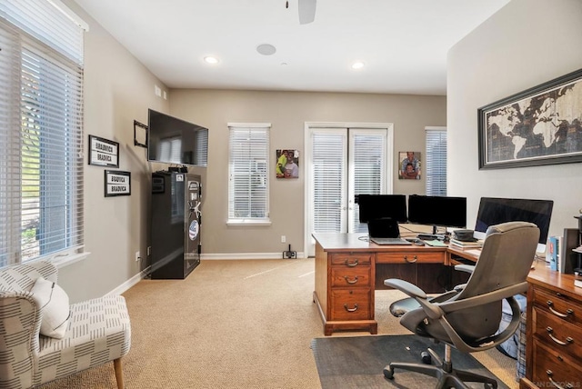 office space featuring light carpet and ceiling fan