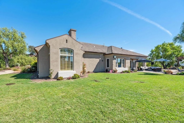 back of property featuring a lawn and a patio